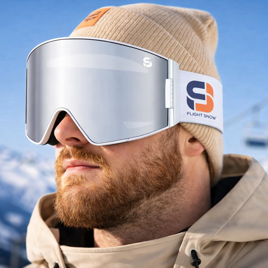 Man wearing a beige beanie and goggles with a ski resort background